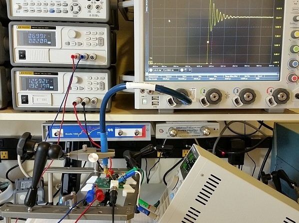 图3：用于DC/DC转换器的完整仪器设置展示。测试板输入电压调节至12V，栅极驱动调节器供电电压为7V。右下方显示了负载，Keysight 90000-X示波器、Teledyne Lecroy PP066传输线探头和Huber Suhner Sucoflex 100电缆等也都可以在图上看见。